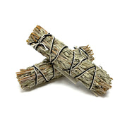 Two small gray sage smudge bundles crossed, wrapped with black and white string