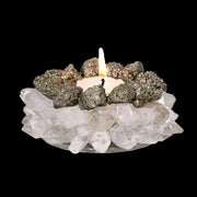 Pyrite and quartz point tea light holder with lit candle, ring of pyrite above clear crystals, black background