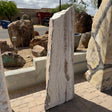 White travertine onyx fountain vertical block with red bands, fine linear striations, shown in gallery stone yard