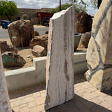 White travertine onyx fountain vertical block with red bands, fine linear striations, shown in gallery stone yard