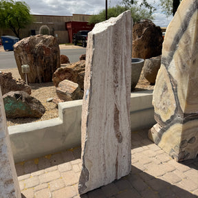 White travertine onyx fountain vertical block with red bands, fine linear striations, shown in gallery stone yard