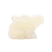 Opalite rabbit carving in milky white glass, crouched in side profile with ears laid back