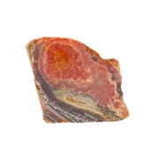 Rhodochrosite end cut specimen with concentric orange eye and pink banding over gray, on white