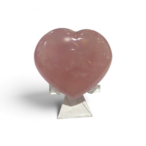 Rose quartz puffy heart with soft pink translucence on a clear display stand
