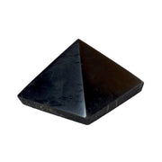 Polished black shungite pyramid, single 5cm piece on a white background