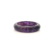Solid carved amethyst band ring in deep saturated purple, front view on white