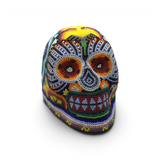 Huichol beaded skull with yellow and orange stripe down the middle and floral beadwork