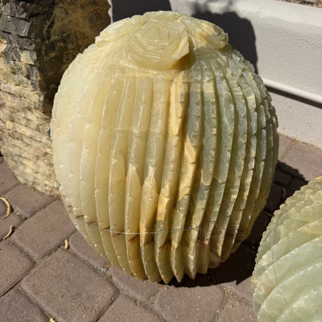 Rounded ribbed onyx cactus fountain with a single rose bloom at the crown