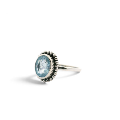 Faceted oval aquamarine bezel set in a beaded flower halo of simple 925 sterling silver