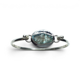 Rare Earth Gallery tension set labradorite bangle bracelet with a rough freeform teal stone and silver bezel edge