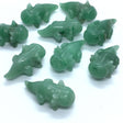 Aventurine axolotl carvings in green stone, several polished figures grouped on white