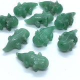 Aventurine axolotl carvings in green stone, several polished figures grouped on white
