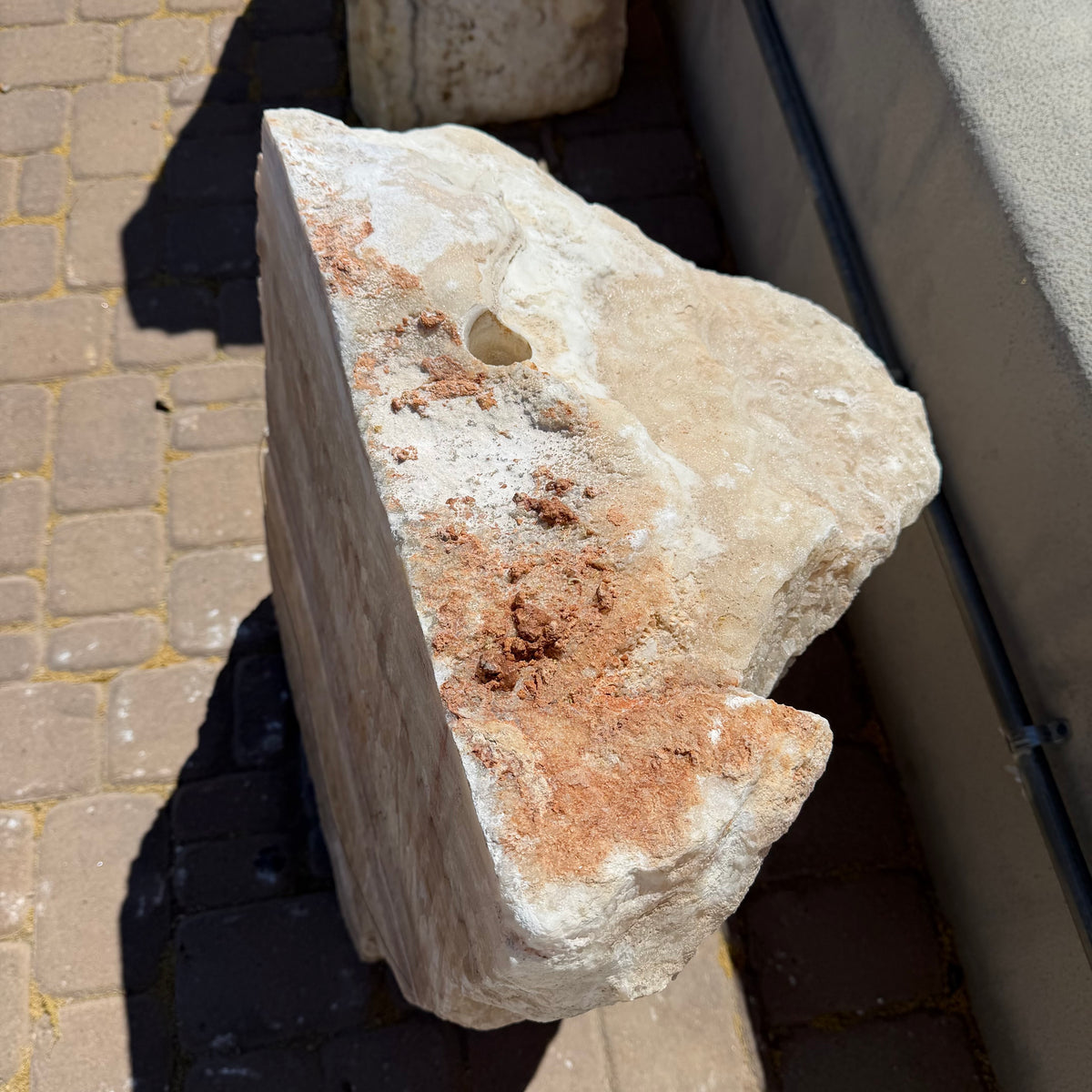 Top view of serpentine onyx boulder fountain showing the drilled center hole and rust inclusions