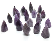 Group of polished purple trapiche amethyst flame points with chevron banding on white