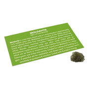 Small single moldavite tektite nugget beside a green Moldavite information card