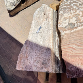 Red Zebra Onyx fountain corner cut showing vertical banding in cream, mauve and charcoal stripes