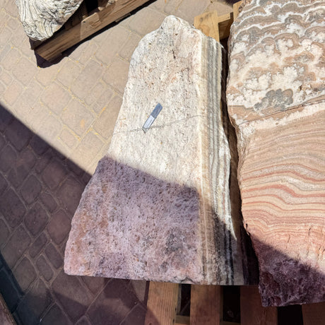 Red Zebra Onyx fountain corner cut showing vertical banding in cream, mauve and charcoal stripes