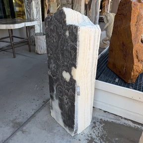 Angled view pairing the dark floral face and pale banded side of the onyx column fountain