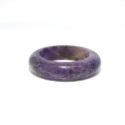 Solid carved amethyst band ring, deep purple with grey mottling, front view on white