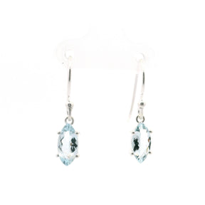 Faceted aquamarine dangle earrings with sharp oval gemstones set in silver hooks.