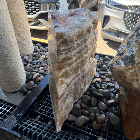 Serpentine onyx boulder fountain from the cut side, sheet of water sliding down the polished face