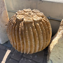 Tan red travertine barrel cactus carving fountain on pavers beside rough travertine slabs
