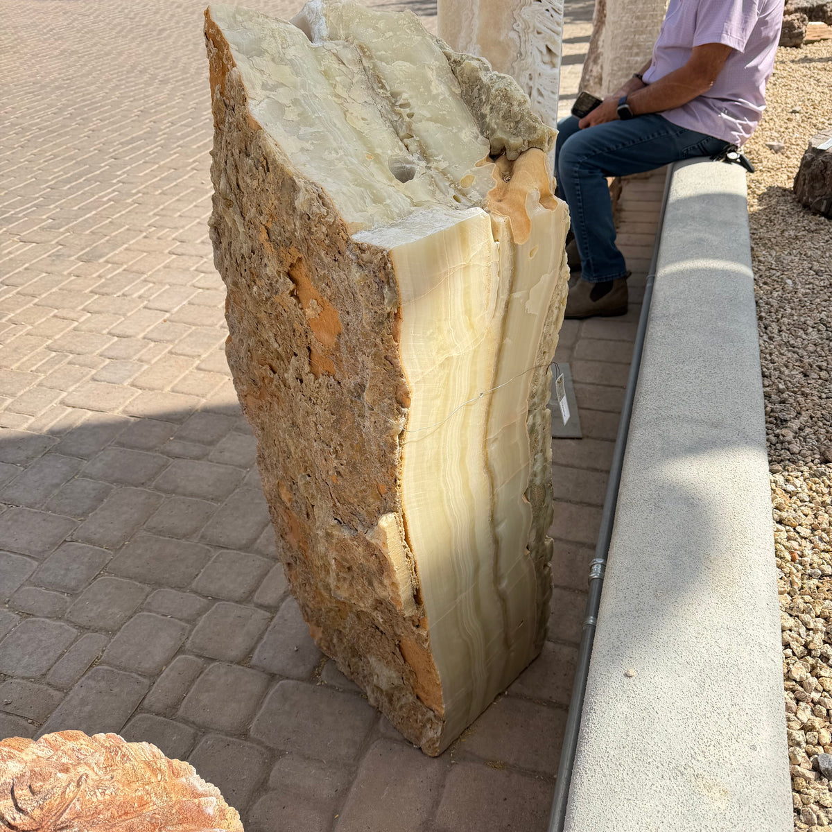 Tall Amber Ice Onyx fountain seen from the side, drilled top hole above a honey-banded polished edge