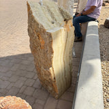 Tall Amber Ice Onyx fountain seen from the side, drilled top hole above a honey-banded polished edge