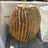 Side view of red travertine barrel cactus fountain showing porous pitted stone and deep flutes