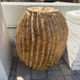 Side view of red travertine barrel cactus fountain showing porous pitted stone and deep flutes