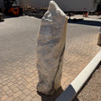 Yellow orange cosmic zebra onyx fountain, tapered pillar with cream and gray banding on paver courtyard