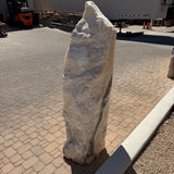 Yellow orange cosmic zebra onyx fountain, tapered pillar with cream and gray banding on paver courtyard