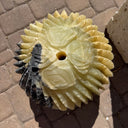 Overhead detail of spiny tips, rose carvings and a black streak around the fountain's drill hole
