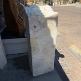 Sunlit face of the White Cosmic Onyx fountain pillar showing swirled cream and white crystal banding