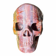 Polychrome agate skull carving front view with pink-mauve face, red banding, and olive-yellow left side