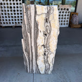 Zebra onyx fountain slab with cream, gold and gray banding standing upright on the gallery patio
