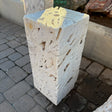 Zebra Fossil Onyx block fountain viewed from above, cream porous stone with cut top set on brick pavers