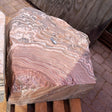 Red zebra onyx fountain stone showing swirling floral radial banding across its cut top