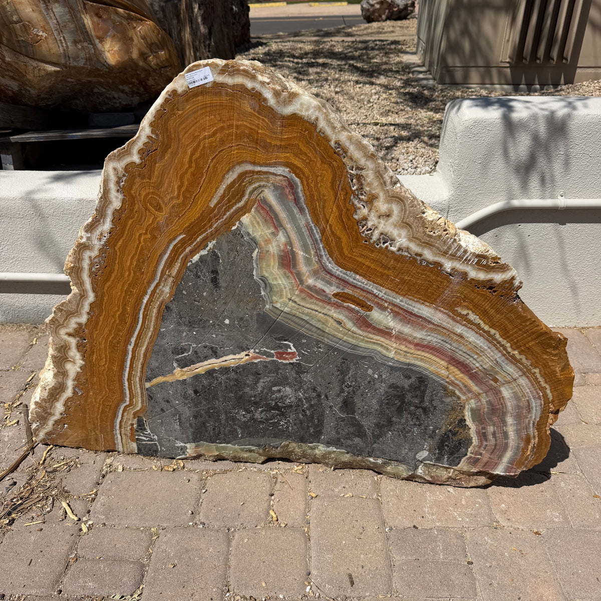 Polished face of the green Talan onyx picture cavern fountain, amber banding around a gray cavern
