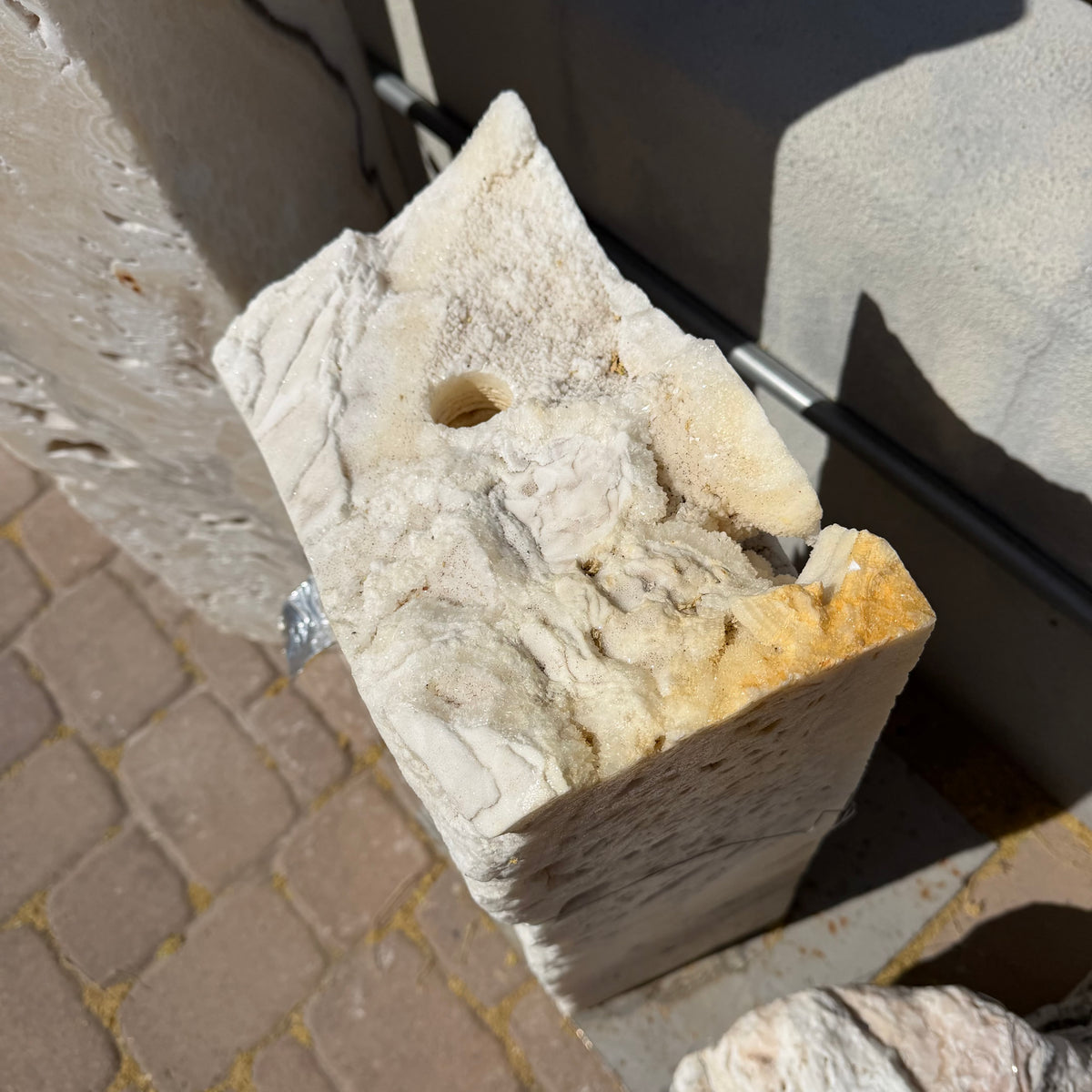 Top of the white fossil onyx column with drilled fountain hole and golden druzy crystal layers