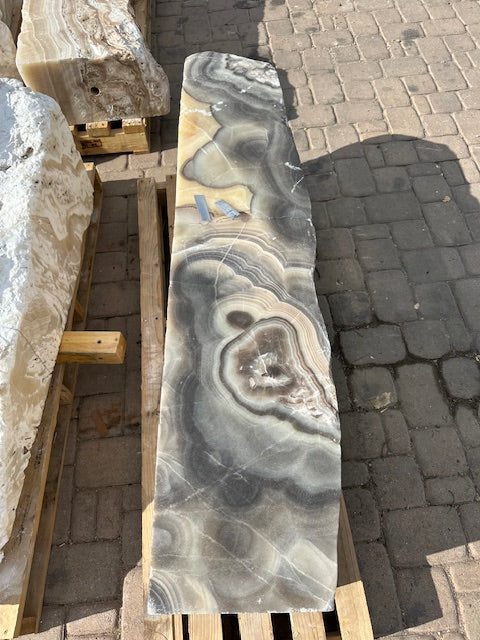 Overhead view of the cosmic onyx pillar's gray banded face with a large concentric vug near the center