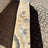 Cosmic onyx fountain pillar on a pallet, wavy cut side with honey and gray banding, viewed from above