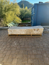 Amber onyx fountain block resting on a wooden pallet outdoors, desert mountain and saguaro backdrop