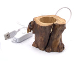 Angled view of the wood tree stump lighted base with USB cord and inline switch beside it