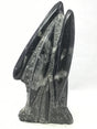Two large glossy black Orthoceras cross-sections rising from the sculpture's rough self-standing base