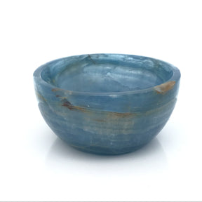 Blue calcite hand-carved round dish with pale blue banded body, three-quarter view