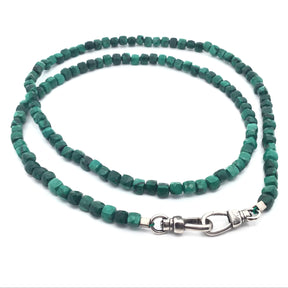 Malachite faceted square bead necklace coiled flat-lay with silver double carabiner clasp