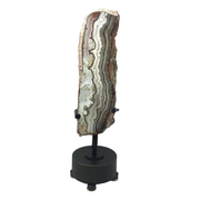Vertical crazy lace agate end cut, polished face with pink and gray banding, on black rotating base