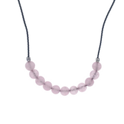 Rose quartz round beads centered on a black cord choker with silver accent beads, close up