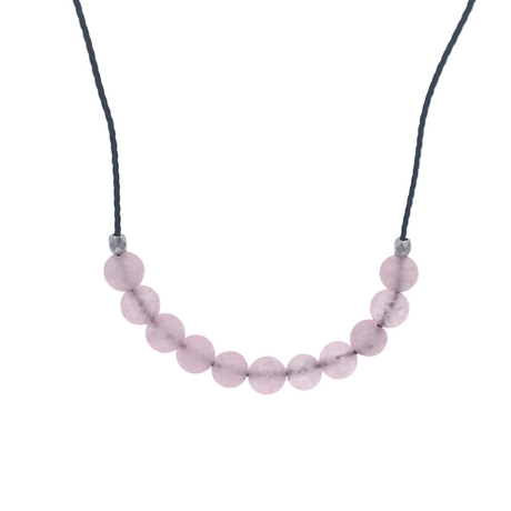 Rose quartz round beads centered on a black cord choker with silver accent beads, close up